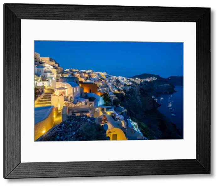 Framed Print : The view from Oia castle along Santorinis caldera during the evening blue hour with Framed Print : The view from Oia castle along Santorinis caldera during the evening blue hour with