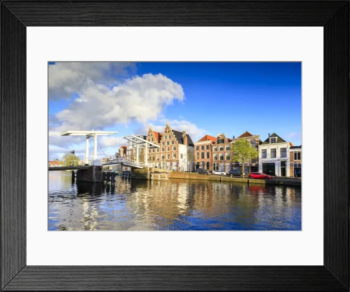Framed Print : Blue sky and clouds on typical houses reflected in the canal of the River Spaarne Framed Print : Blue sky and clouds on typical houses reflected in the canal of the River Spaarne