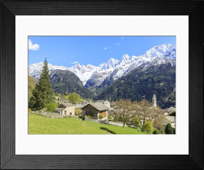 Framed Print : View of Soglio between meadows and snowy peaks in spring, Maloja, Bregaglia Valley Framed Print : View of Soglio between meadows and snowy peaks in spring, Maloja, Bregaglia Valley