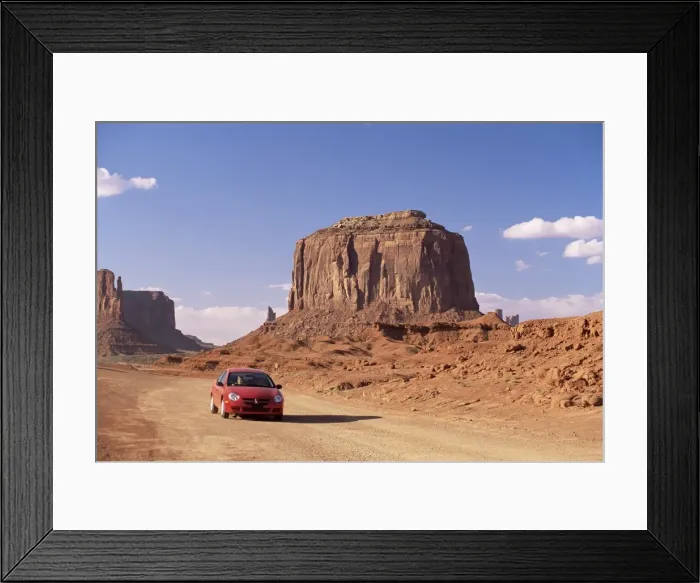 Framed Print : Car on valley drive road beneath Merrick Butte Framed Print : Car on valley drive road beneath Merrick Butte