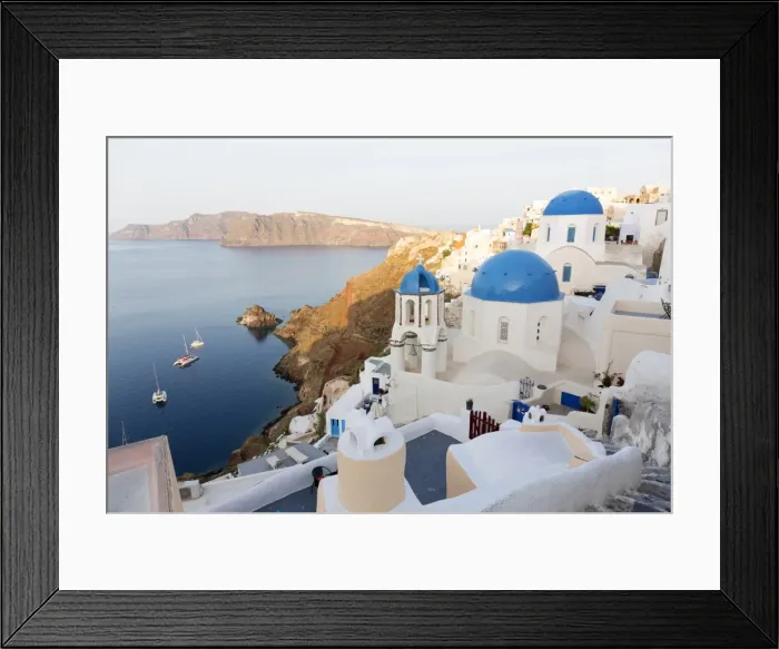 Framed Print : Classic view of the village of Oia with its blue domed churches and colourful houses Framed Print : Classic view of the village of Oia with its blue domed churches and colourful houses