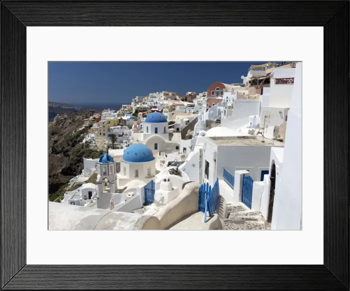 Framed Print : Classic view of the village of Oia with its blue domed churches and colourful houses Framed Print : Classic view of the village of Oia with its blue domed churches and colourful houses
