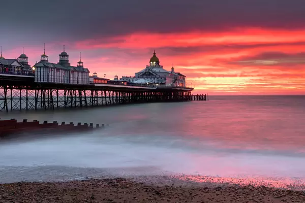 Eastbourne Pier against fiery red sky at sunrise, Eastbourne, East Sussex, England