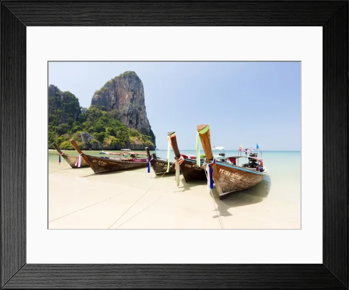 Framed Print : Traditional Longtail boats moored by Railay Beach with limestone cliffs in the background Framed Print : Traditional Longtail boats moored by Railay Beach with limestone cliffs in the background