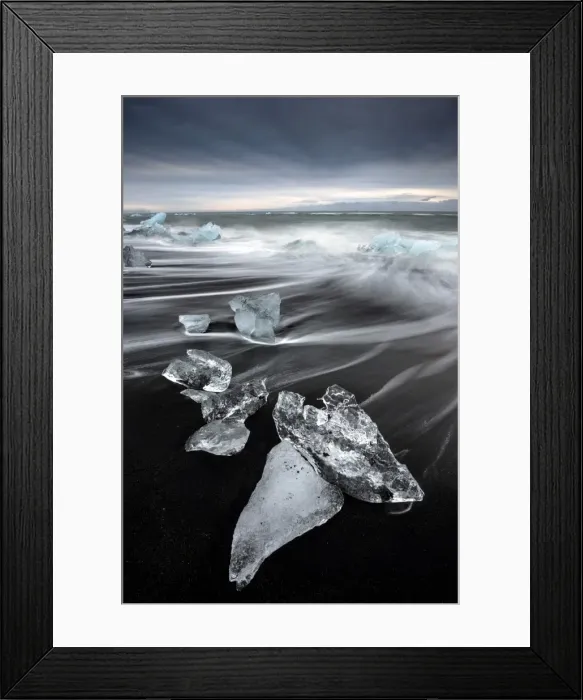 Framed Print : Glassy pieces of ice on volcanic black sand beach with blurred waves, near Jokulsarlon Lagoon Framed Print : Glassy pieces of ice on volcanic black sand beach with blurred waves, near Jokulsarlon Lagoon