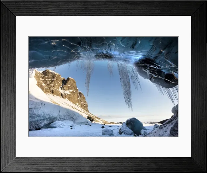 Framed Print : View from ice cave towards sunlit mountains with icicles hanging from cave entrance Framed Print : View from ice cave towards sunlit mountains with icicles hanging from cave entrance