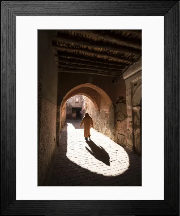 Framed Print : Local man dressed in traditional djellaba walking through archway in a street in the Kasbah Framed Print : Local man dressed in traditional djellaba walking through archway in a street in the Kasbah
