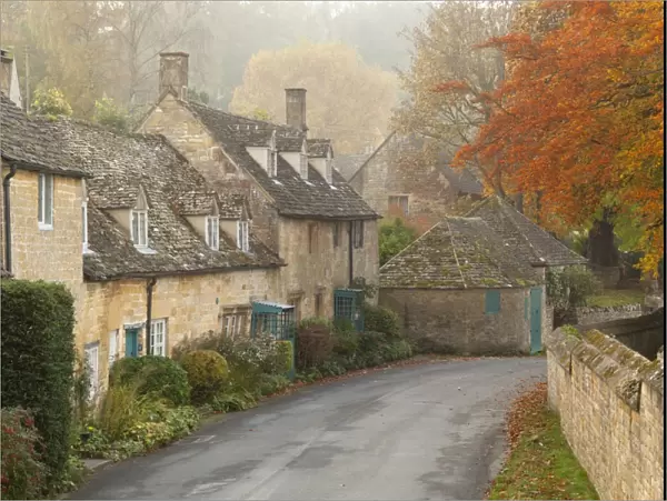 Line of Cotswold stone cottages in autumn mist, Snowshill, Cotswolds, Gloucestershire
