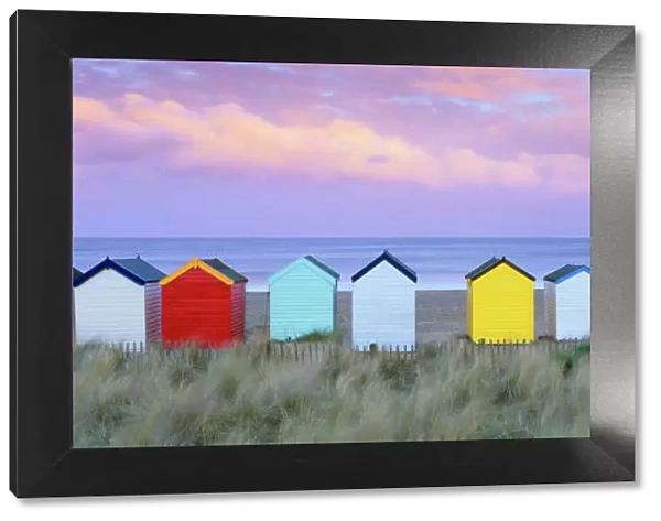 Colourful beach huts and sand dunes at sunset, Southwold, Suffolk, England, United Kingdom