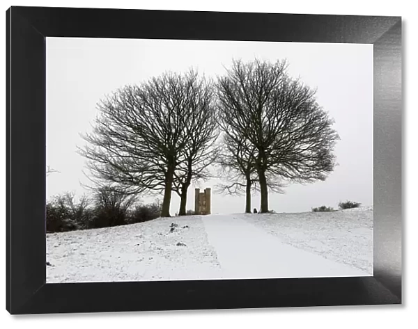 Broadway Tower framed by bare trees in snow, Broadway, Cotswolds, Worcestershire
