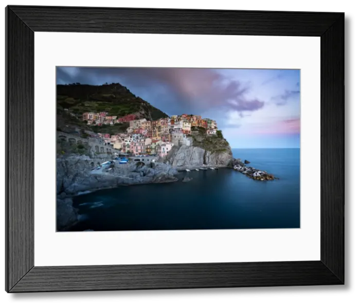 Framed Print : The clouds over Manarola light up with the colours of sunset during a long exposure Framed Print : The clouds over Manarola light up with the colours of sunset during a long exposure