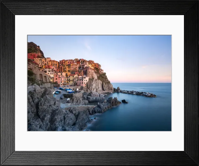 Framed Print : Beautiful sunset light shines on the colourful town of Manarola during a long exposure Framed Print : Beautiful sunset light shines on the colourful town of Manarola during a long exposure