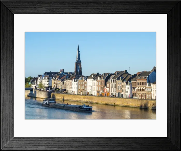 Framed Print : A boat passes buildings along the Meuse (Ms) River in the Wyck-Ceramique quarter