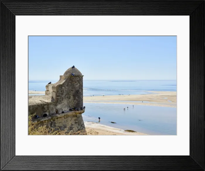Framed Print : Beachgoers crossing a lagoon formed by the low tide, and detail of a watchtower in Cacela Velha Framed Print : Beachgoers crossing a lagoon formed by the low tide, and detail of a watchtower in Cacela Velha