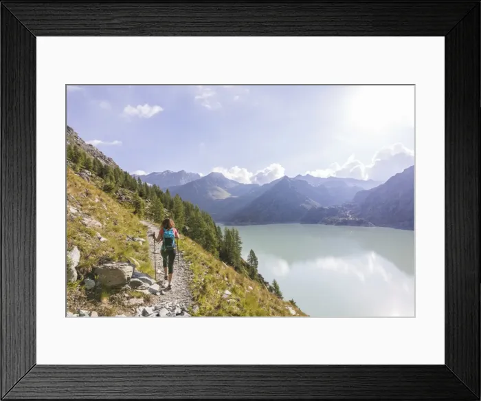 Framed Print : Hiker on path towards Rifugio Bignami beside the dam and water basin of Alpe Gera Framed Print : Hiker on path towards Rifugio Bignami beside the dam and water basin of Alpe Gera