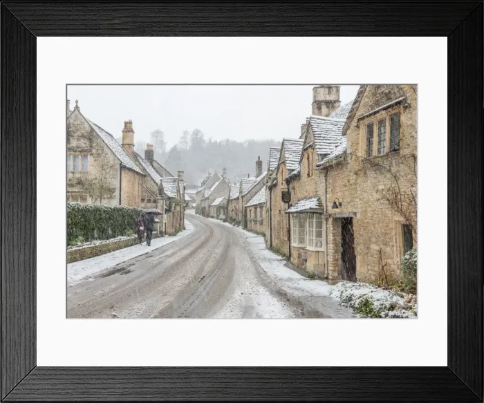 Framed Print : A couple walking up the hill in Castle Combe with an umbrella protecting them Framed Print : A couple walking up the hill in Castle Combe with an umbrella protecting them