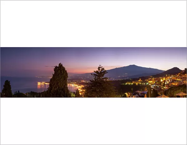 Panoramic view of Mount Etna and Giardini Naxos at dusk from Taormina, Sicily, Italy