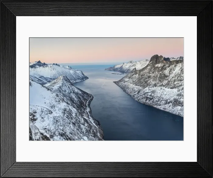 Framed Print : Top view of the snowy peaks surrounding Fjordgard framed by the frozen sea at sunset