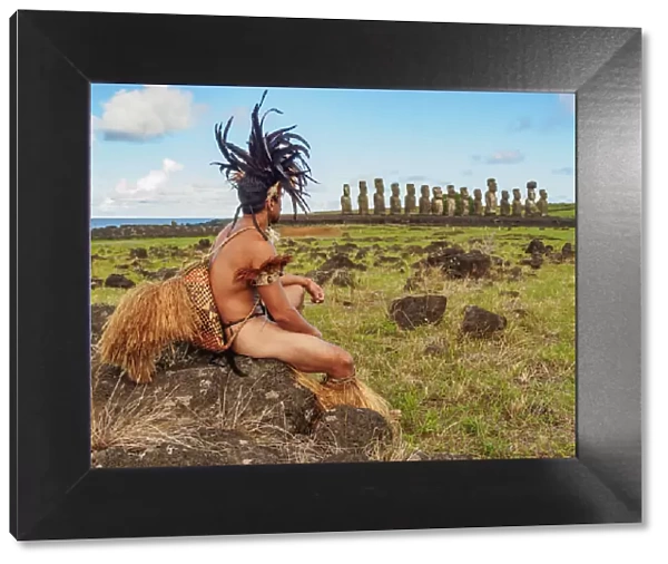 Native Rapa Nui man in tradititional costume and Moais in Ahu Tongariki, Rapa Nui National Park