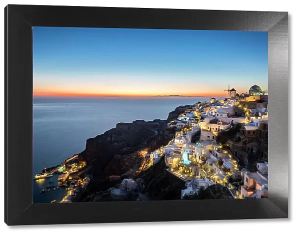 Long exposure sunset view over the whitewashed buildings and windmills of Oia, Santorini