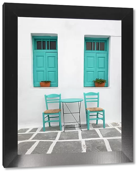 Typical Greek cafe table and chairs with shuttered windows, Pano Chora, Serifos, Cyclades