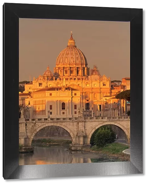View over Tiber River to Ponte Vittorio Emanuele II Bridge and St. Peters Basilica at sunrise