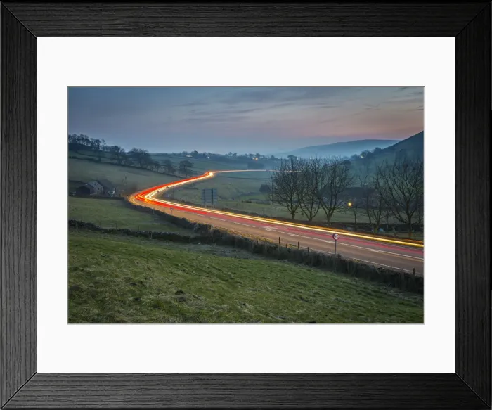 Framed Print : View of vehicle trail lights on A623 at Sparrowpit at dusk, Peak District National Park Framed Print : View of vehicle trail lights on A623 at Sparrowpit at dusk, Peak District National Park