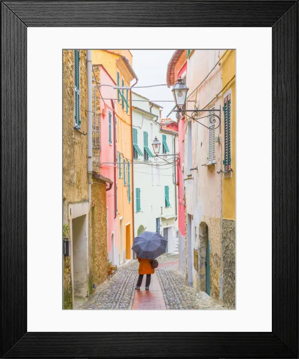 Framed Print : A person with an umbrella in the main street of Civezza, Province of Imperia, Liguria Framed Print : A person with an umbrella in the main street of Civezza, Province of Imperia, Liguria