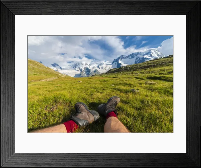 Framed Print : Hiker rests on grass looking towards Monte Rosa massif, Riffelalp, Zermatt, canton of Valais Framed Print : Hiker rests on grass looking towards Monte Rosa massif, Riffelalp, Zermatt, canton of Valais