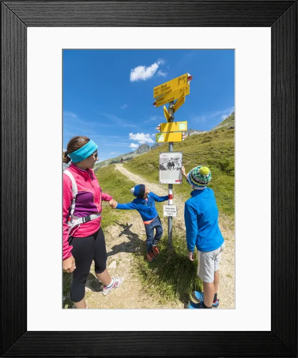 Framed Print : Mother and sons look at the signpost of hiking trails, Spluga Pass, Chiavenna Valley Framed Print : Mother and sons look at the signpost of hiking trails, Spluga Pass, Chiavenna Valley