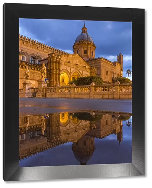 The illuminated Palermo Cathedral (UNESCO World Heritage Site) reflected in a puddle