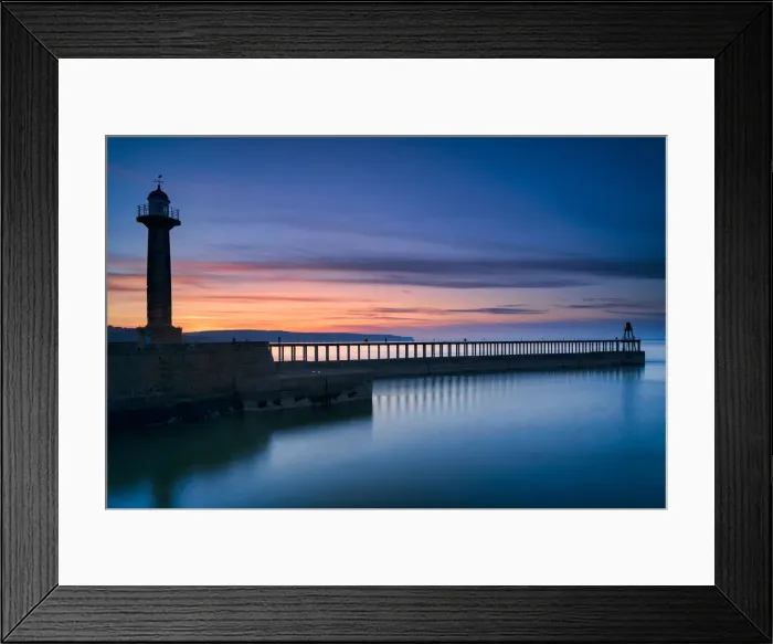 Framed Print : Sunset afterglow over Whitby West Pier and lighthouse, the North Yorkshire coast