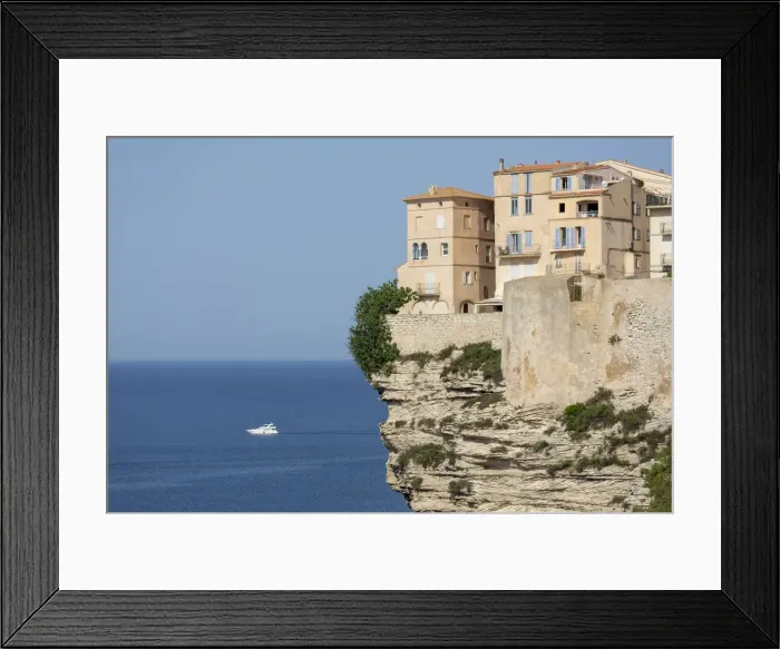 Framed Print : The Citadel and old town of Bonifacio perched on rugged cliffs with boat in the Mediterranean