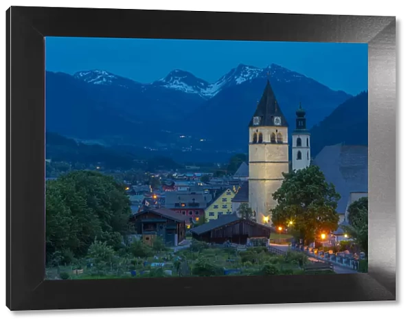 View of Liebfrauenkirche and town and surounding mountains at dusk, Kitzbuhel, Austrian