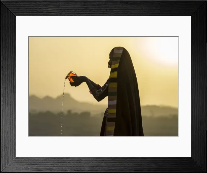 Framed Print : Ahir Woman in traditional colorful cloth pouring water at sunset, Great Rann of Kutch Framed Print : Ahir Woman in traditional colorful cloth pouring water at sunset, Great Rann of Kutch