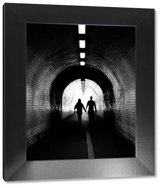 Couple walking into the light, York tunnel, York, England, United Kingdom, Europe