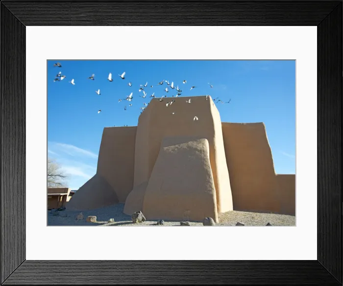 Framed Print : Flock of pigeons flying from the historic adobe San Francisco de Asis church in Taos