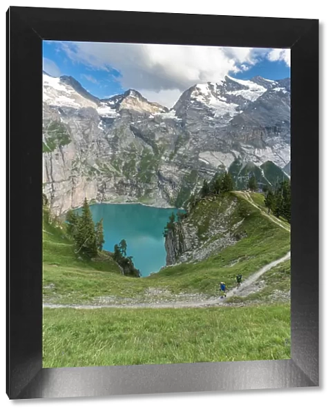 High angle view of two hikers walking on path above Oeschinensee lake, Bernese Oberland