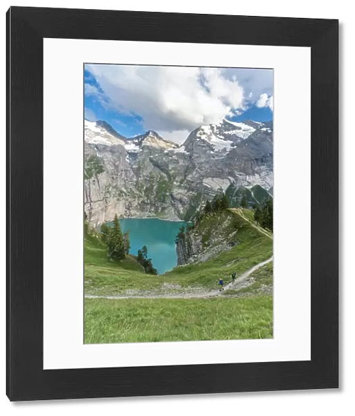 High angle view of two hikers walking on path above Oeschinensee lake, Bernese Oberland