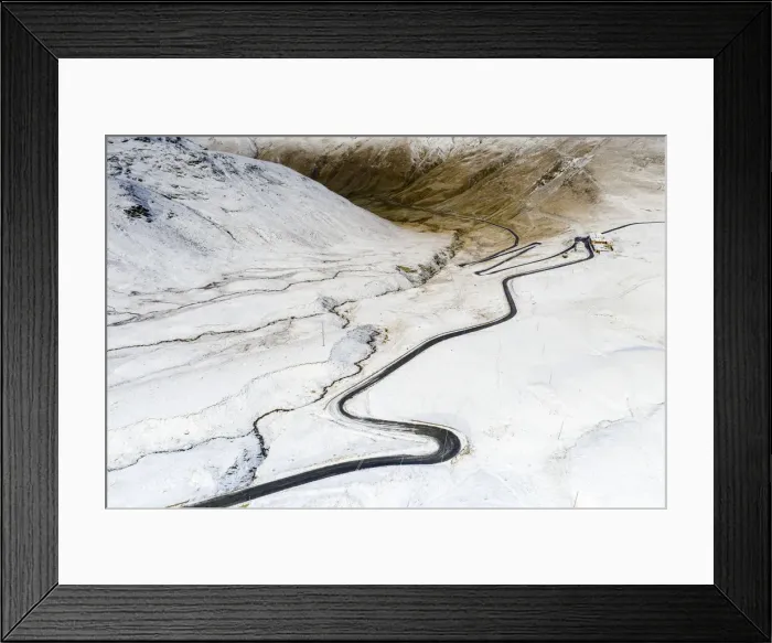 Framed Print : Aerial view by drone of S-shape road towards Stelvio Pass in the snowy landscape, Bormio Framed Print : Aerial view by drone of S-shape road towards Stelvio Pass in the snowy landscape, Bormio
