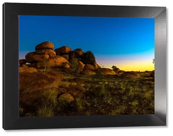 Outback landscape of Devils Marbles rock formations after twilight, granite boulders