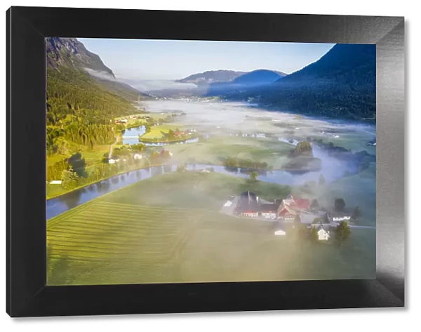 Fog over farms and fields along Stryneelva river, aerial view, Stryn, Nordfjorden