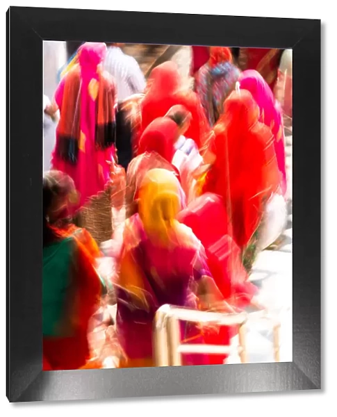 Brightly coloured saris (clothing) and veils, blurred in motion for effect