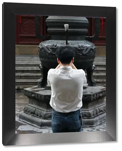 Prayer with incense in the Shanghai White Jade Buddha temple, Shanghai, China, Asia