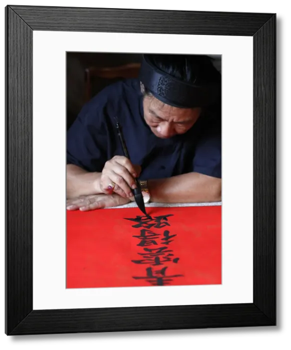 Framed Print : Man doing traditional Chinese writing (calligraphy) in ink using a brush Framed Print : Man doing traditional Chinese writing (calligraphy) in ink using a brush