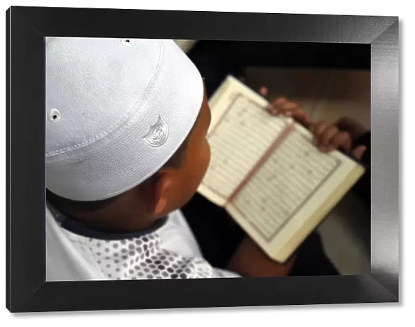 Muslim boy learning Quran at Islamic school, with Kufi hat, Ho Chi Minh City, Vietnam