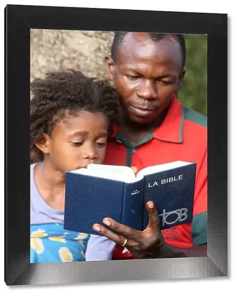 Father and daughter reading the Bible, Lome, Togo, West Africa, Africa