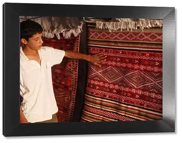 Boy showing a rug in a carpet shop, Toujane, Tunisia, North Africa, Africa