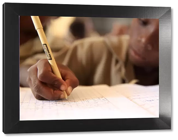 Pupil taking notes in French class in African primary school, Lome, Togo, West Africa
