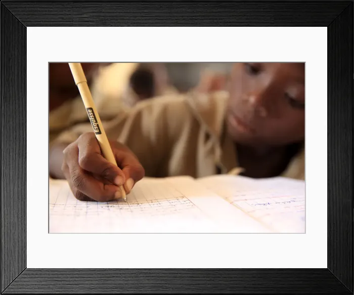 Framed Print : Pupil taking notes in French class in African primary school, Lome, Togo, West Africa Framed Print : Pupil taking notes in French class in African primary school, Lome, Togo, West Africa